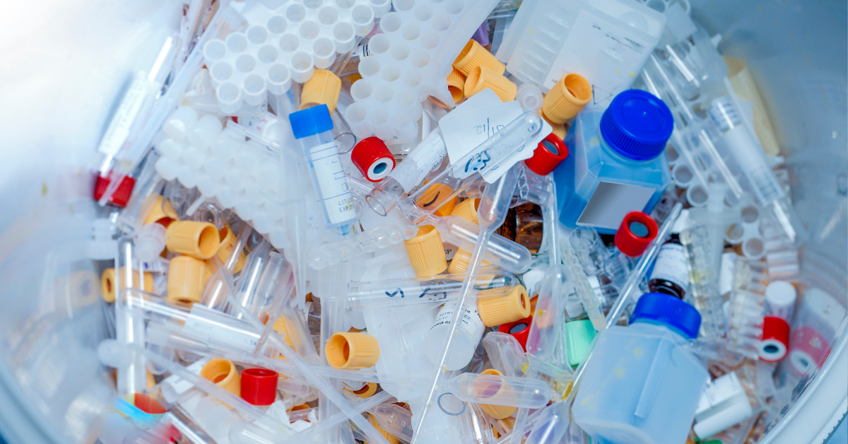 A trash bin filled with hazardous lab materials